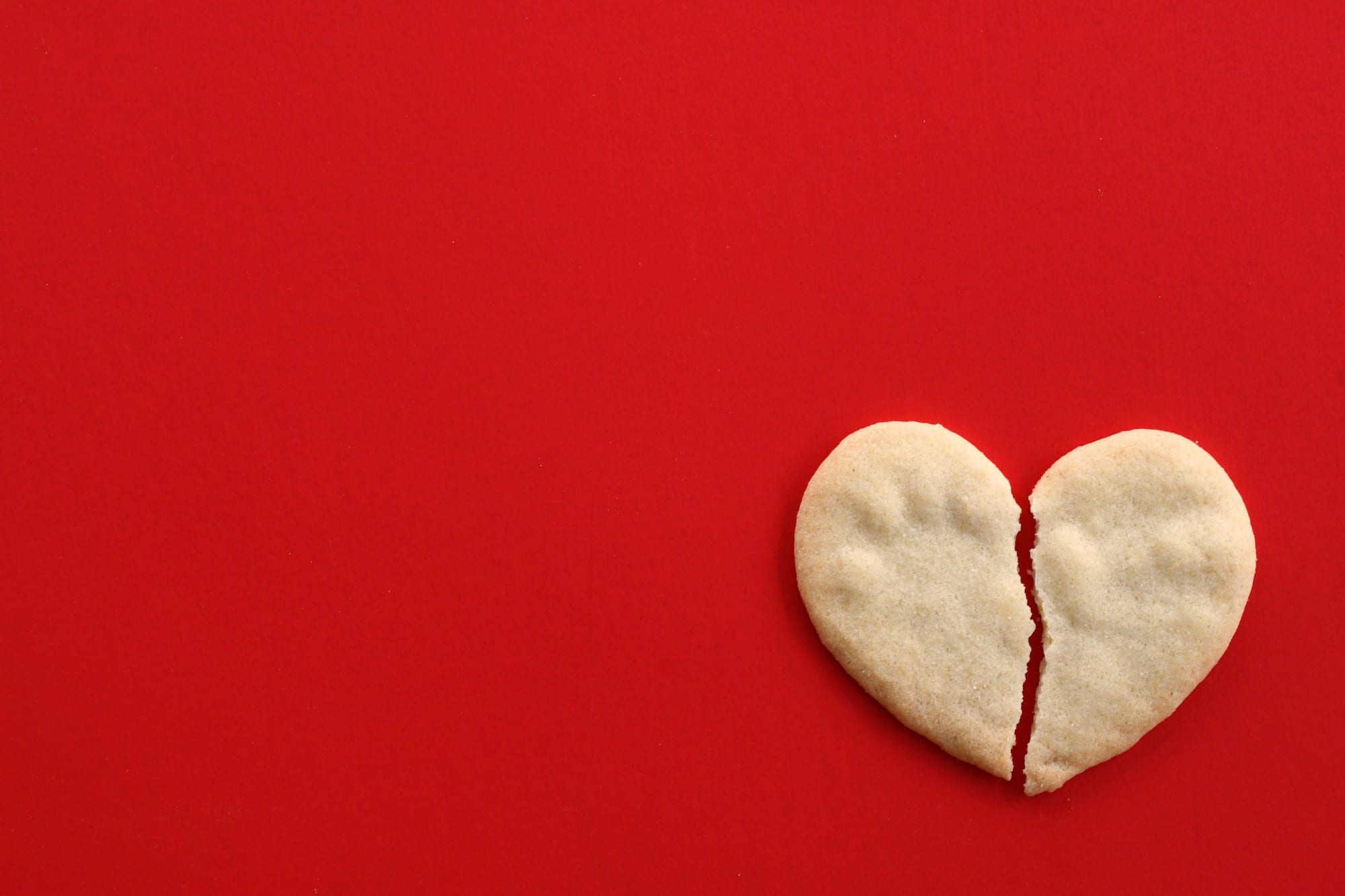 broken heart cookie on red concept breaking up