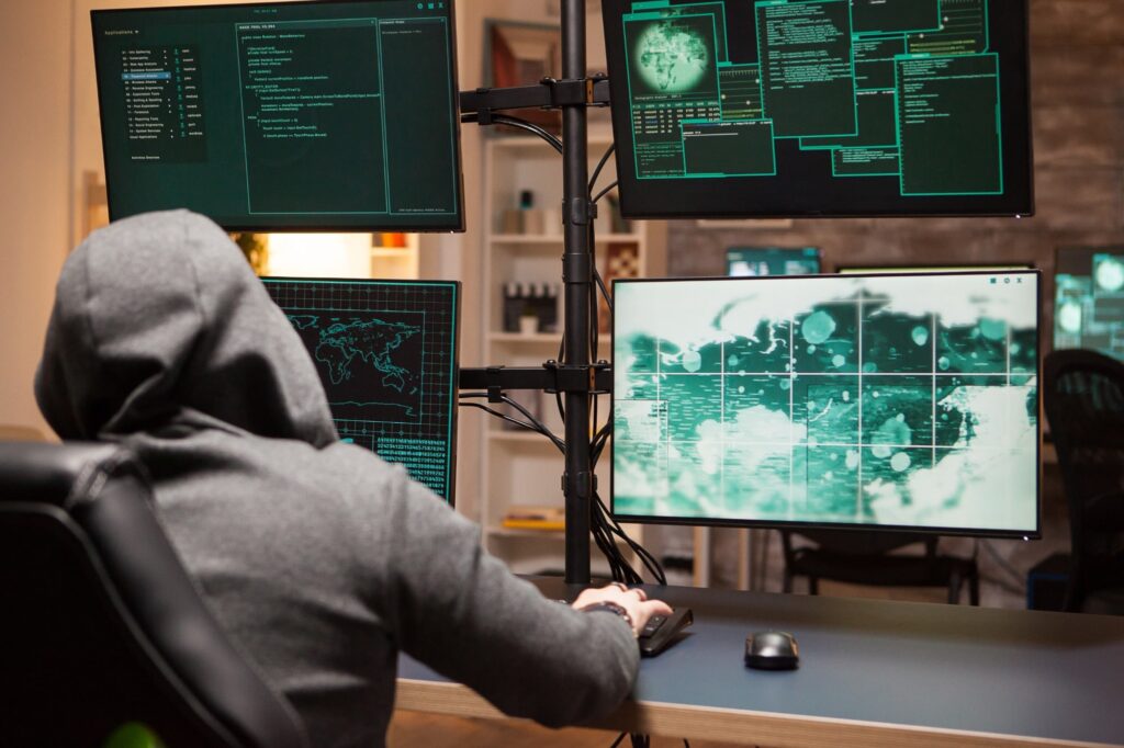 cyber criminal wearing a hoodie writing dangerous code