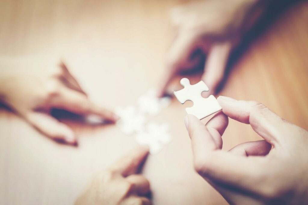 high angle view of businesspeople hand solving jigsaw puzzle