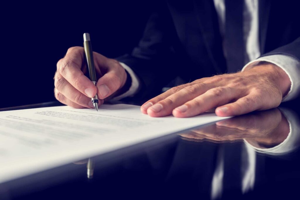 man in suit signing legal document