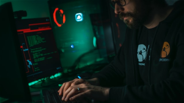 man writing code in dark room